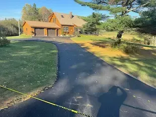 A brand new driveway leading up to a tan house in Bangor, Maine