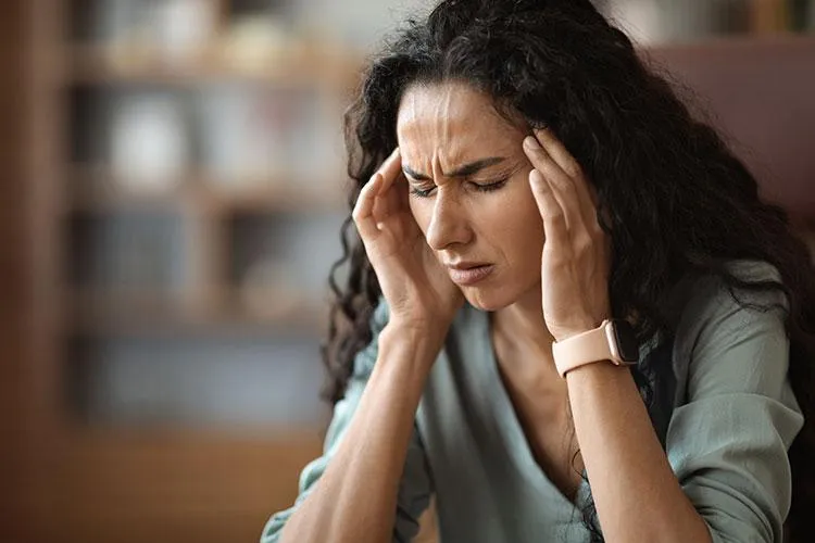 woman rubbinh her temples over complexity of women's health issues at Naturopathic Physicians Group in Scottsdale and Phoenix,