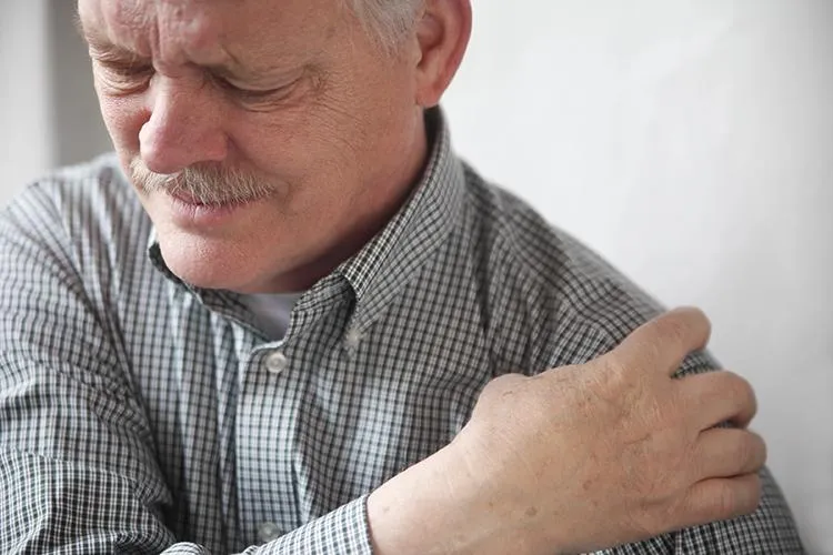 Elderly man experiencing shoulder pain, highlighting the need for regenerative shoulder treatments at Naturopathic Physicians Group.