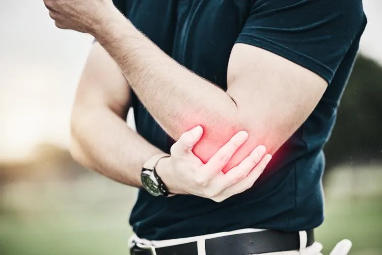 Man experiencing tennis elbow pain, showcasing the benefits of naturopathic elbow pain treatments.