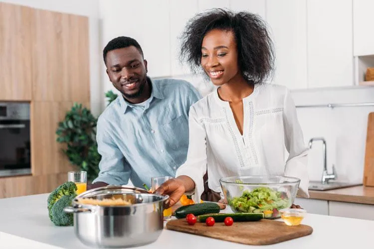 Smiling couple enjoying a healthy salad, symbolizing improved digestive health through naturopathic care in Scottsdale and Phoenix.