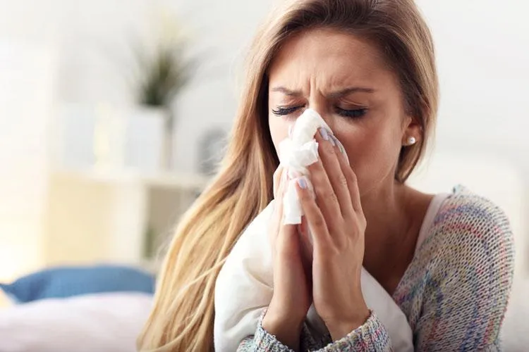 woman blowing her nose in need of immune and wellness care from Naturopathic Physicians Group in Scottsdale, AZ.