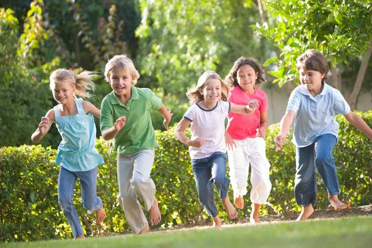 Children running and playing outdoors, representing holistic pediatric care for wellness and development.