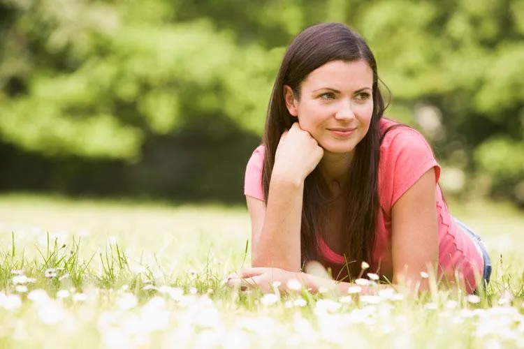 young woman lying outdoors in field allergy free at Naturopathic Physicians Group in Scottsdale and Phoenix,