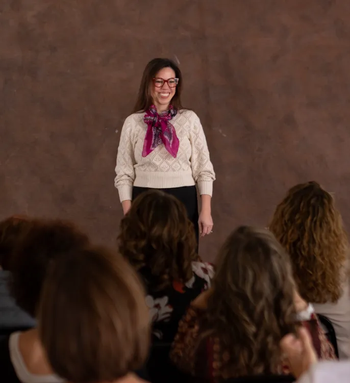 Christina McLoughlin speaking to an audience about personal growth, confidence, and transformational change