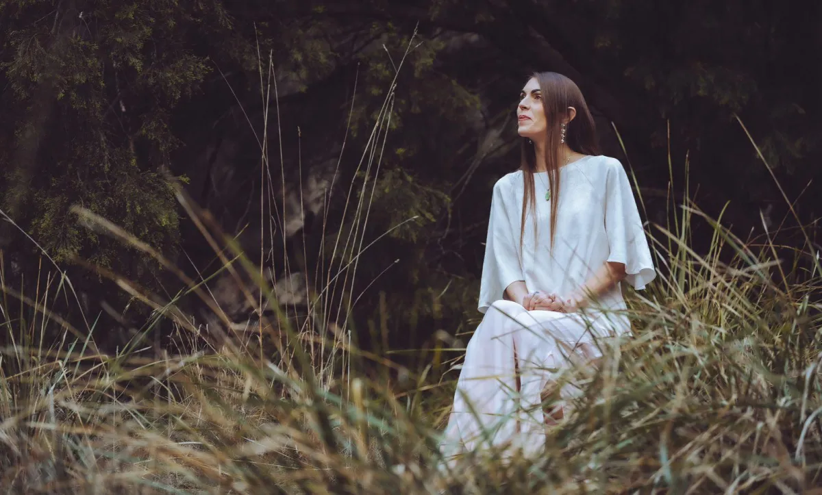 Sacred feminine figure framed by arches, roses, and golden light