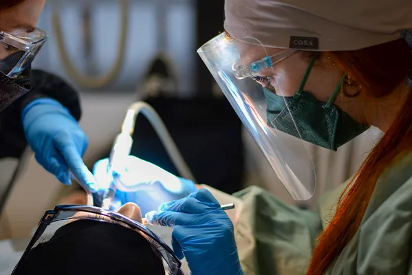 Dental team performing a clinical procedure on a patient.