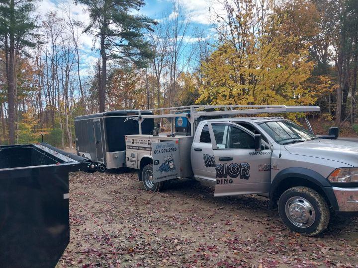 Warrior Welding branded truck and trailer setup in forested autumn location, representing fully mobile welding fleet in New England
