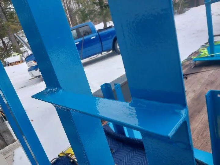 Blue MIG-welded steel cross beam used in structural fabrication, highlighting Warrior Welding’s durable and accurate welds