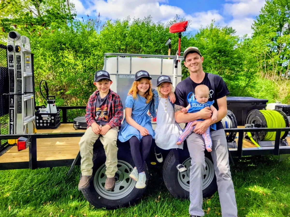 JC Hydro Blast owner Jason smiling outdoors with his four young children in West Michigan.