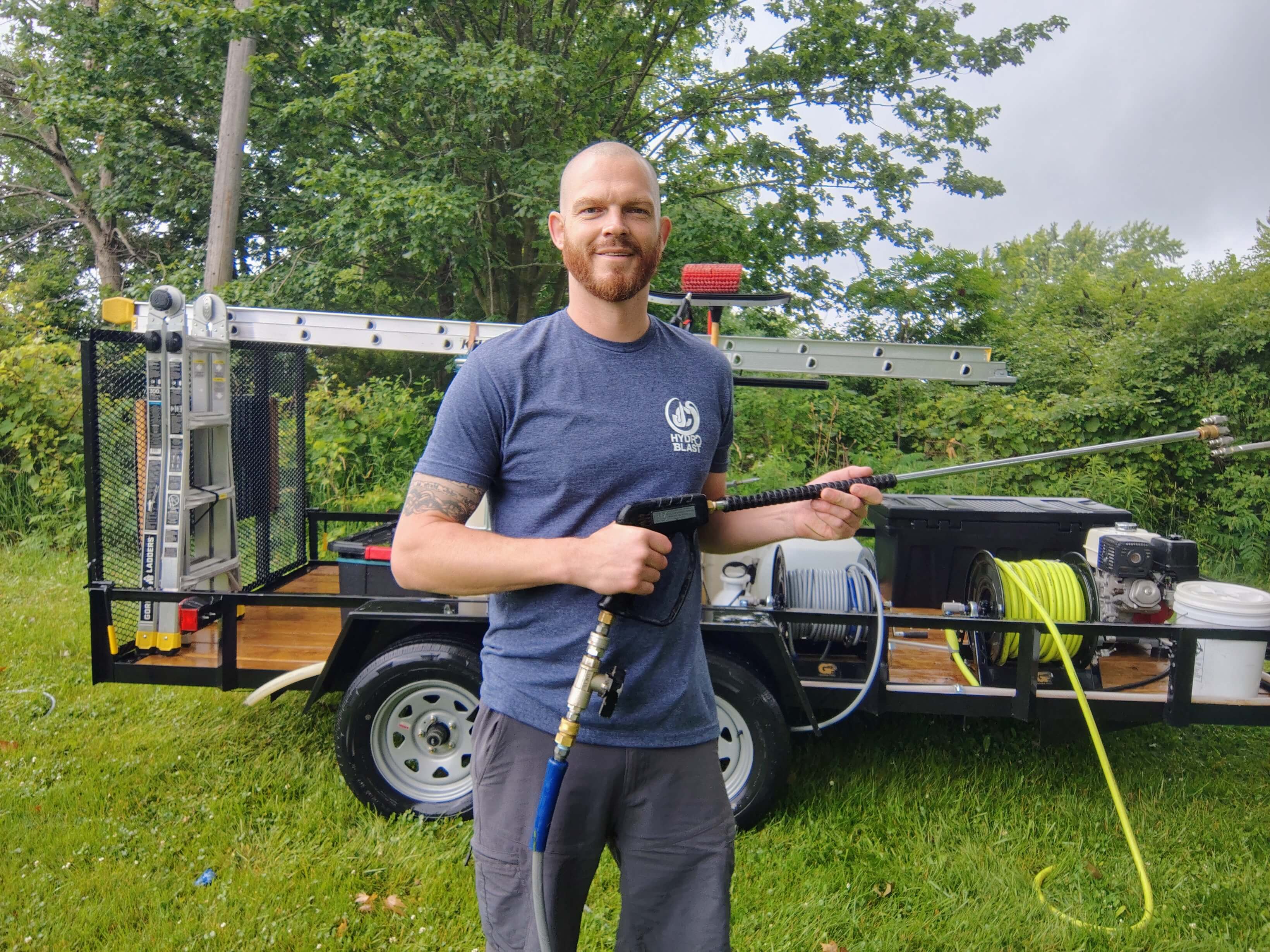 JC Hydro Blast owner in West Michigan equipped with a professional pressure washing trailer and gear.