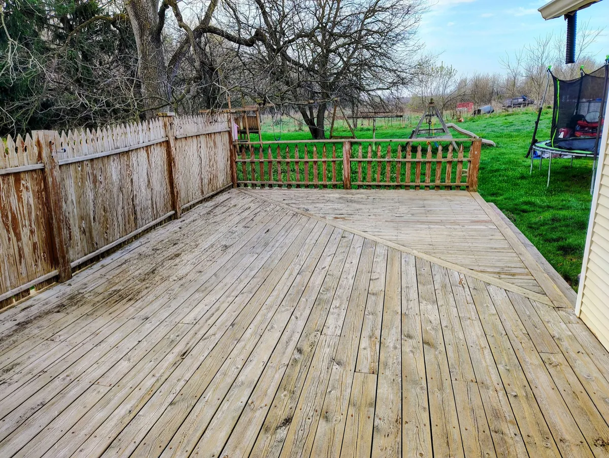 Cleaned wooden deck restored after pressure washing service in West Michigan.