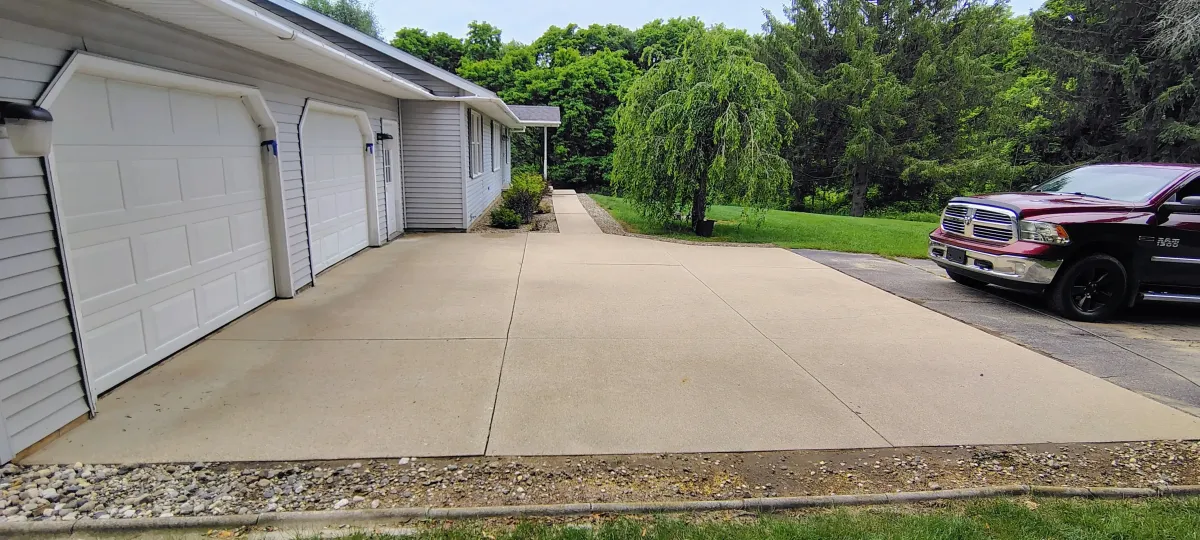 Clean, bright concrete driveway and walkway after a professional pressure washing treatment in West Michigan.