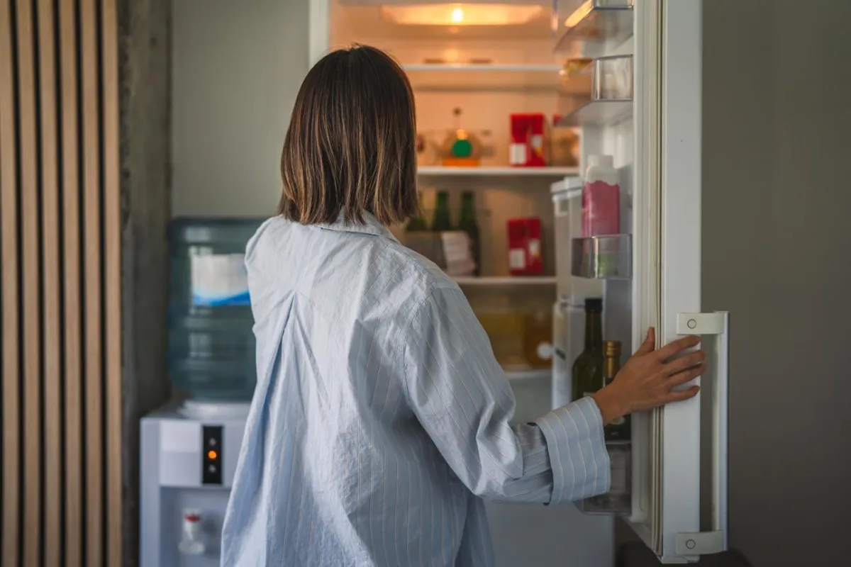 woman looking in refrigerator for snack