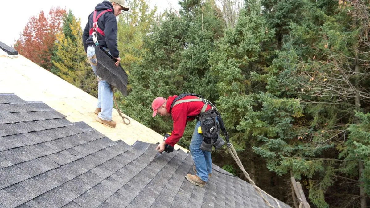 Roofing professionals installing shingles on a residential roof, emphasizing Hook Roofing & Construction's craftsmanship and attention to detail.