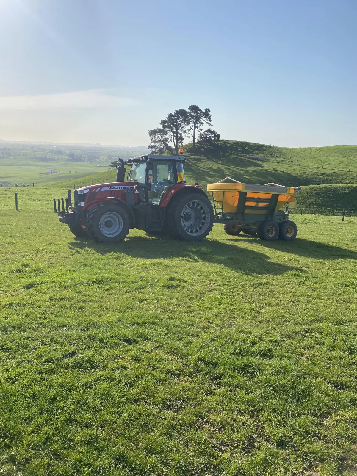 Tractor spreading fertiliser evenly across Waikato farmland for healthy pasture growth