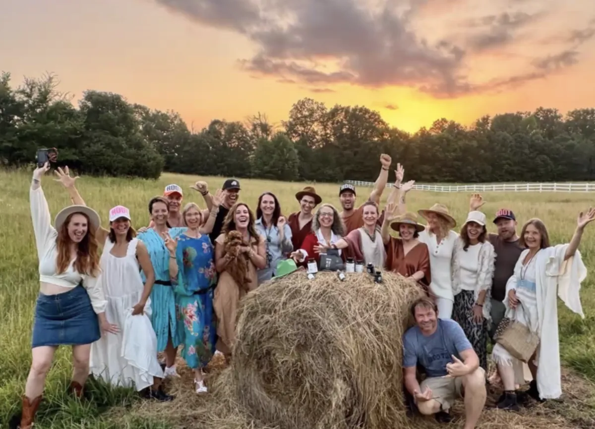 team of people on a meadow with the sunset in the background