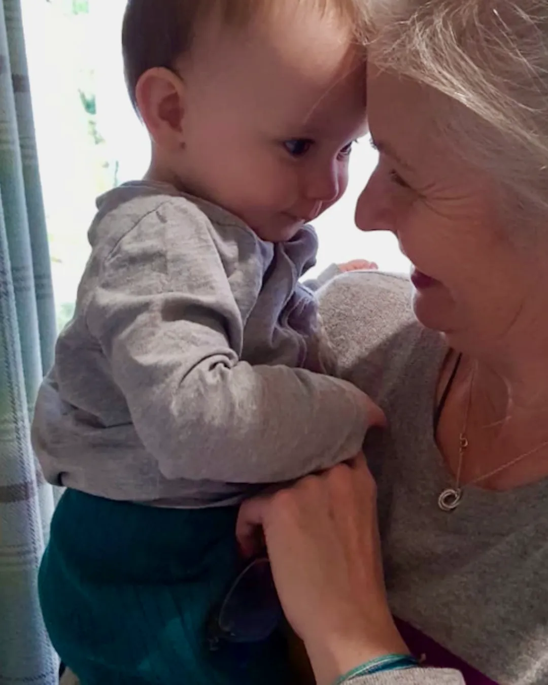 Image of Annie Barber, founder of Wise & With Child. She is holding a little toddler close and they are looking at eachother and smiling