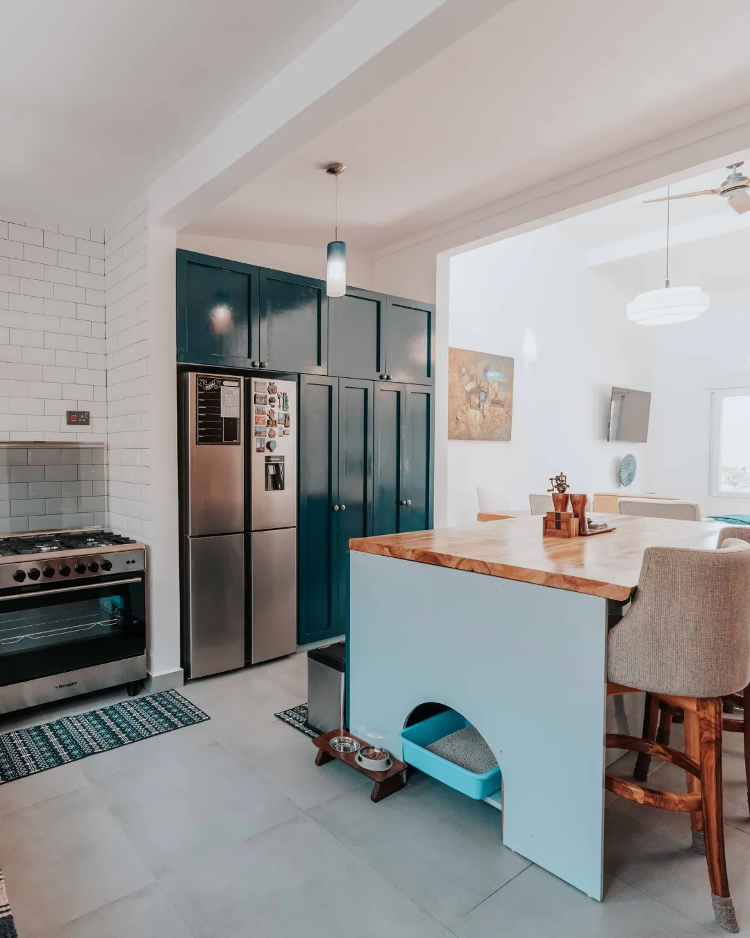 Modern buildings line a calm blue river with boats.