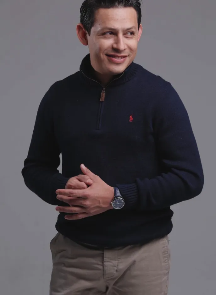 Portrait of a senior barber consulting a client with sample hairstyle book open, soft studio lighting, full-length portrait oriented to emphasize professional service and trust.