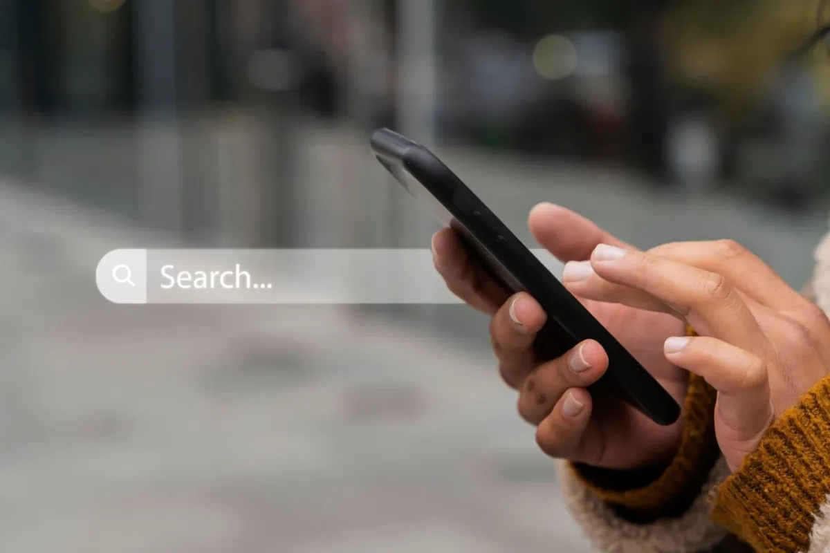 a person holding a phone to search for website 