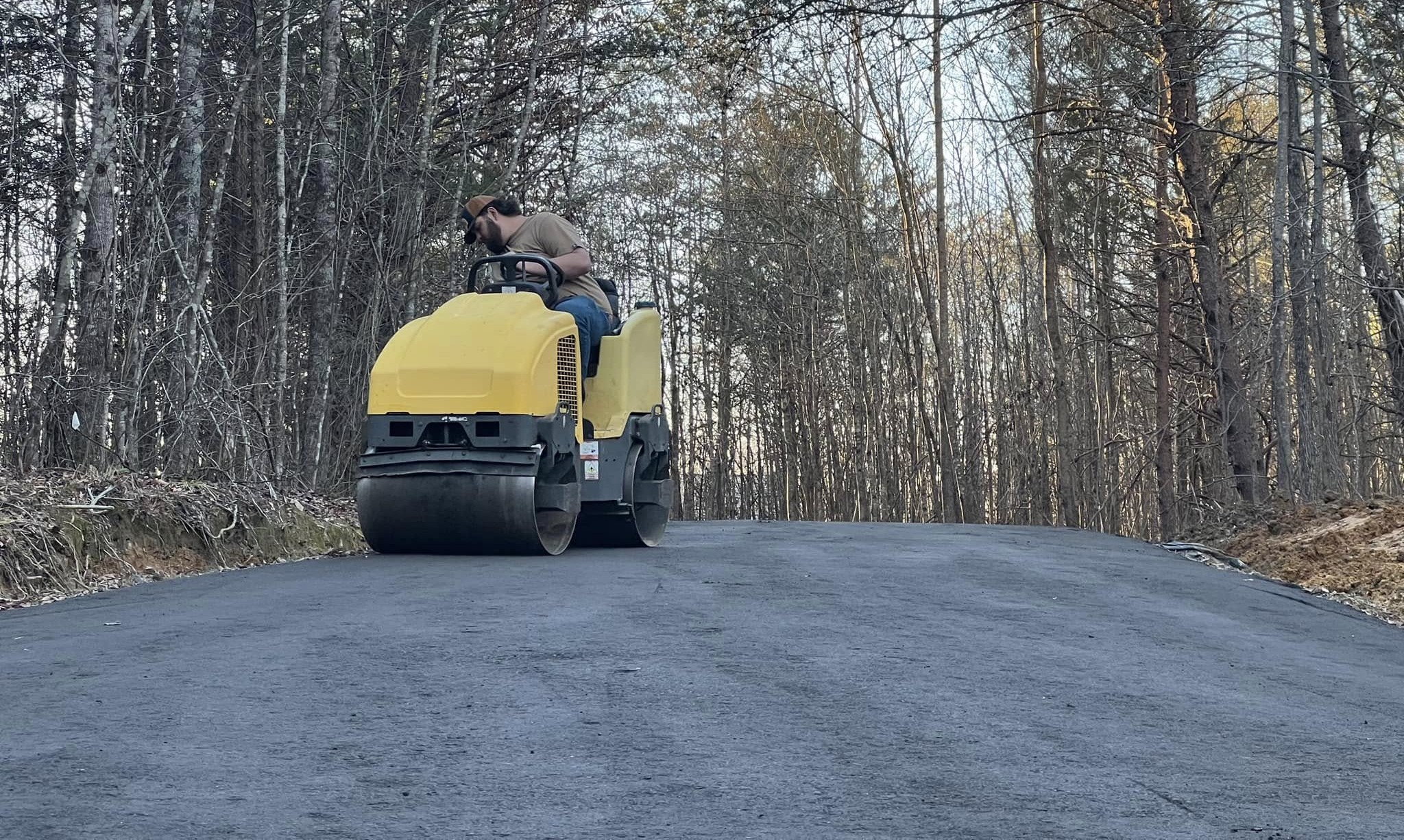 Airport tarmac resurfacing work at night with machinery and workers.