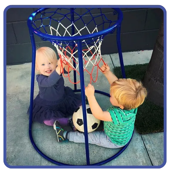 Toddlers enjoying active outdoor play with a basketball hoop at Beginnings Learning Center