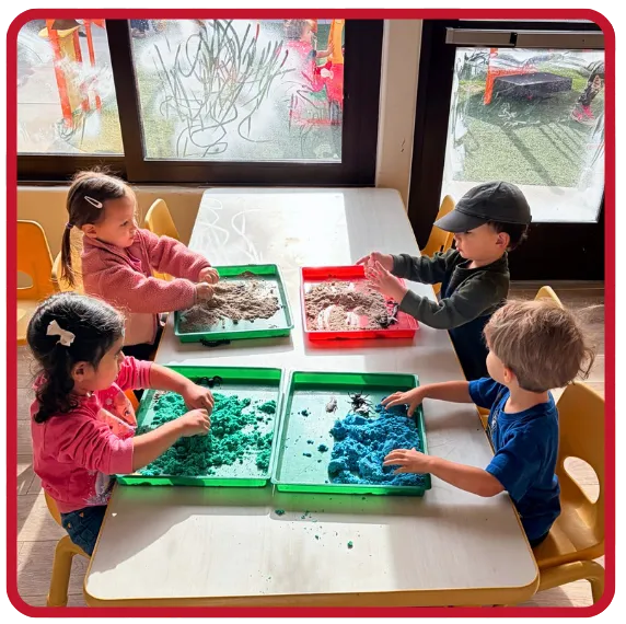 Preschool children exploring sensory materials together during a hands-on classroom activity at Beginnings Learning Center