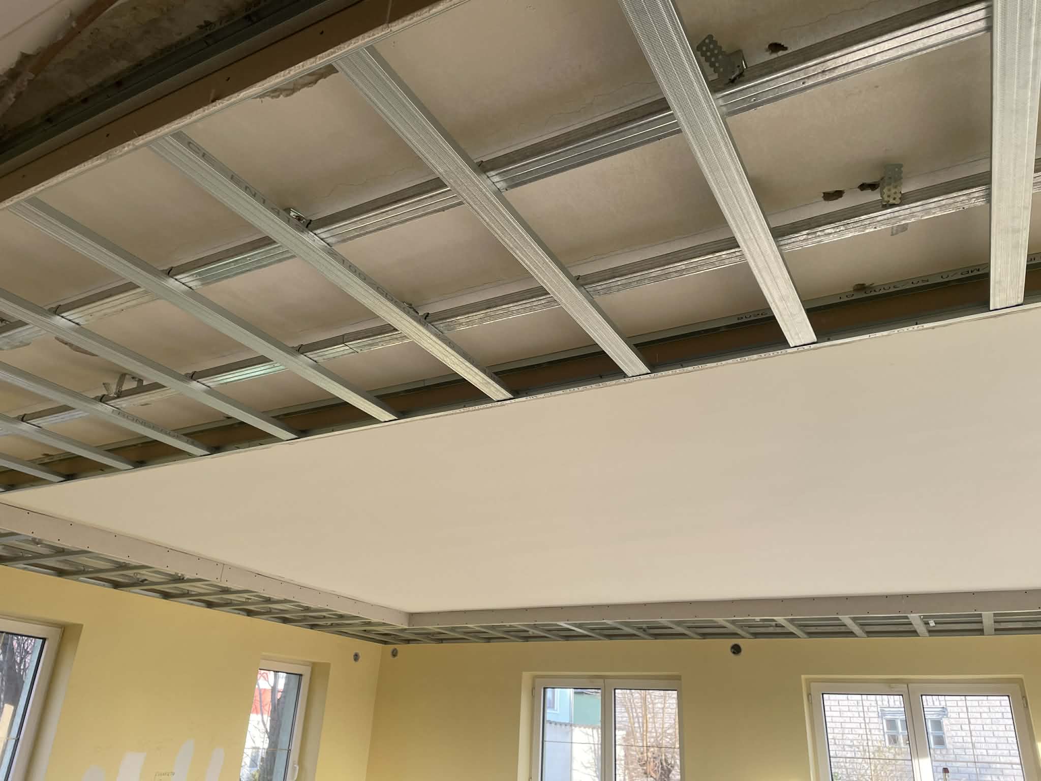 Interior room under construction with exposed framing and ceiling.