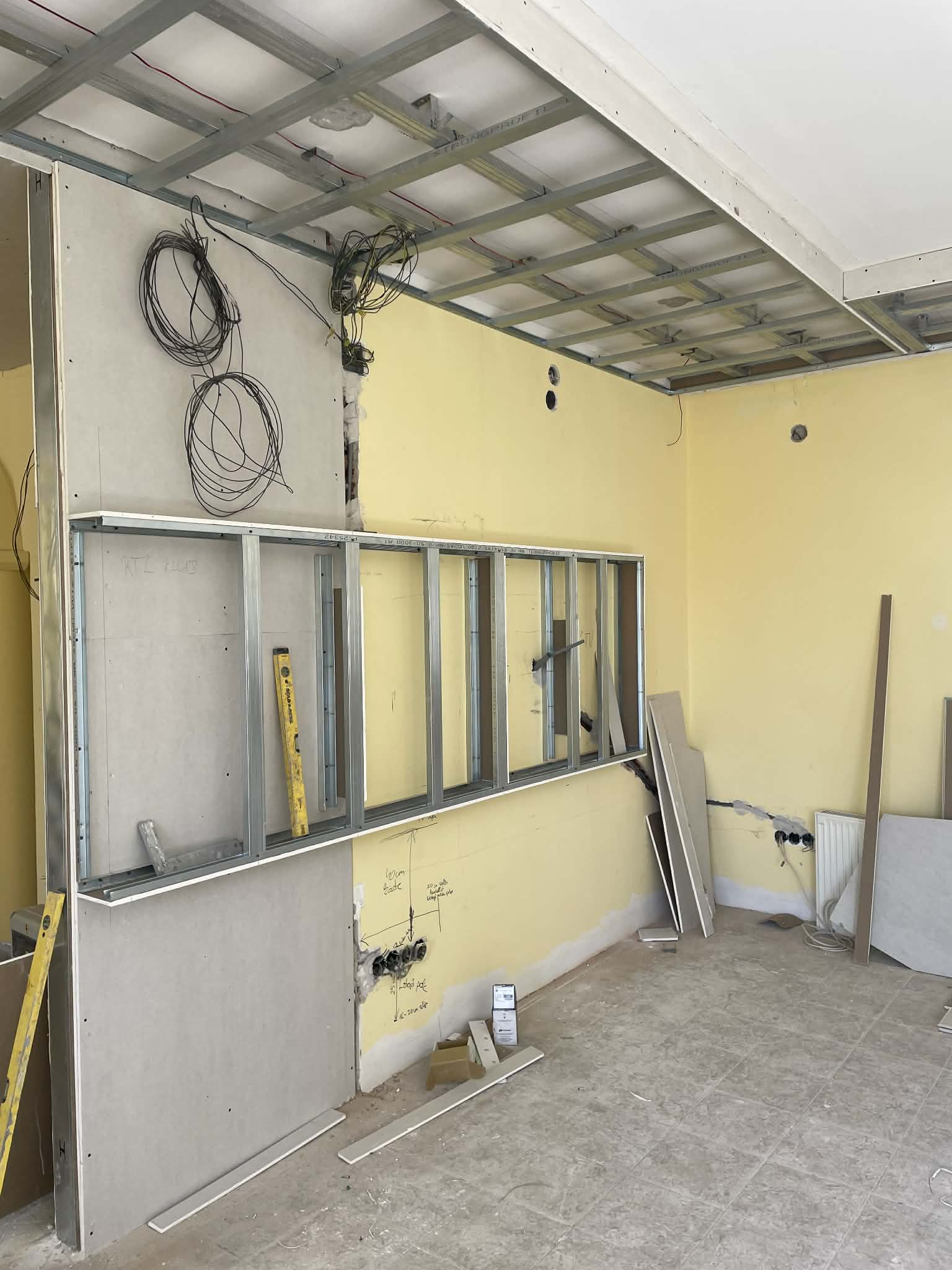 Interior room under construction with exposed framing and ceiling.
