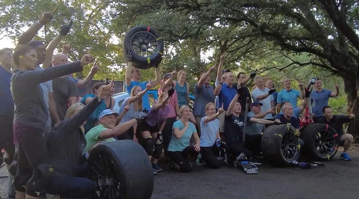 Row of dumbbells in a modern gym with a person working out in the background.