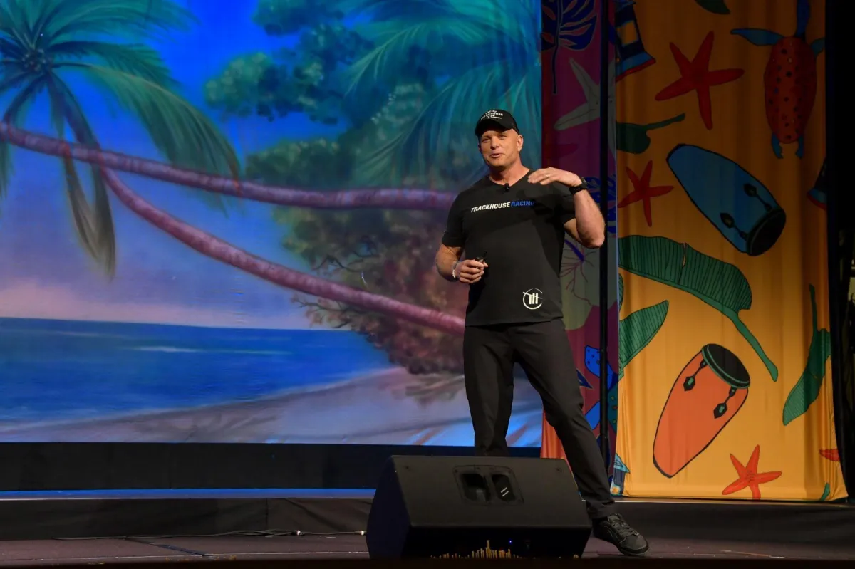 Shaun Peet delivering a high-energy keynote presentation on mindset, resilience, and peak performance during a national conference event.