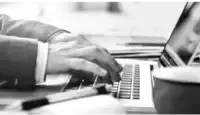 Man typing at his desk on a computer