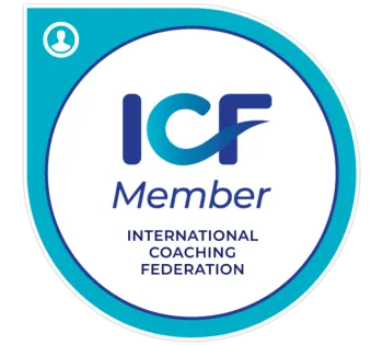 A circular badge with a blue and white design representing membership in the International Coaching Federation (ICF). The badge features the ICF logo with a stylized swoosh through the letters 'ICF' in bold blue, followed by the word 'Member' in a smaller font. Below, 'International Coaching Federation' is written in capital letters. The outer edge of the badge is a thick blue border with a small icon of a person in the top left corner.