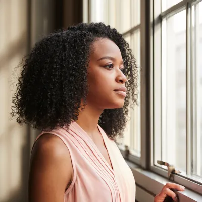 woman feeling aimless staring out the window.