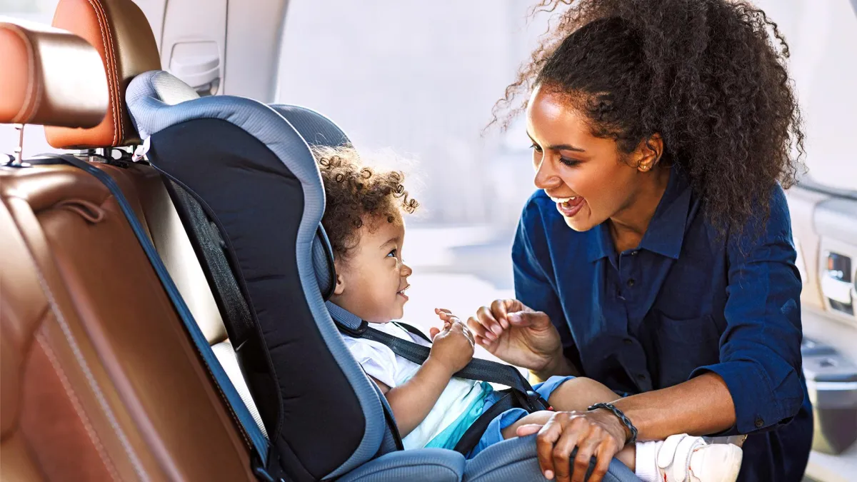 une maman attache son enfant dans l'auto
