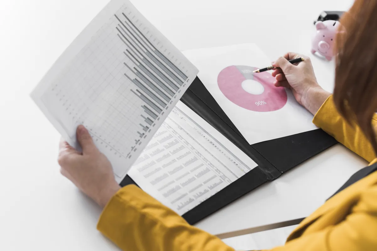 Businesswoman analyzing financial charts and graphs with bar chart and pie chart reports