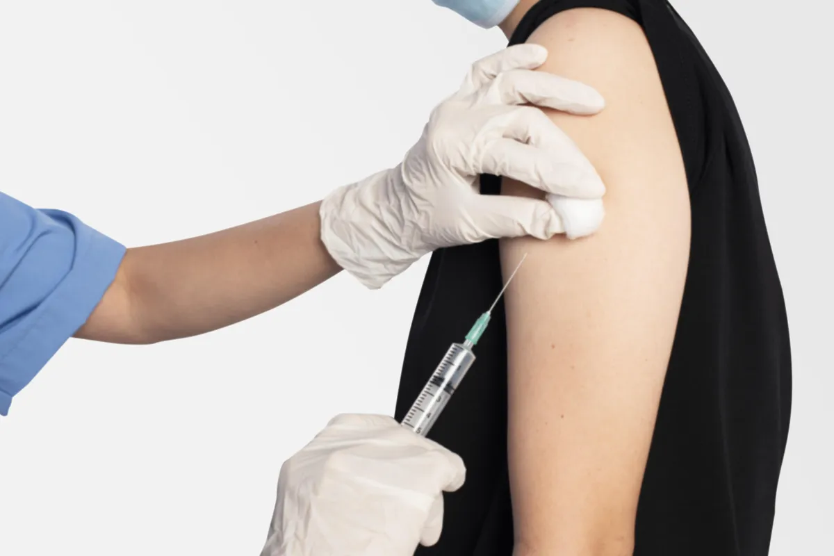 Healthcare professional administering vaccine injection into patient’s arm