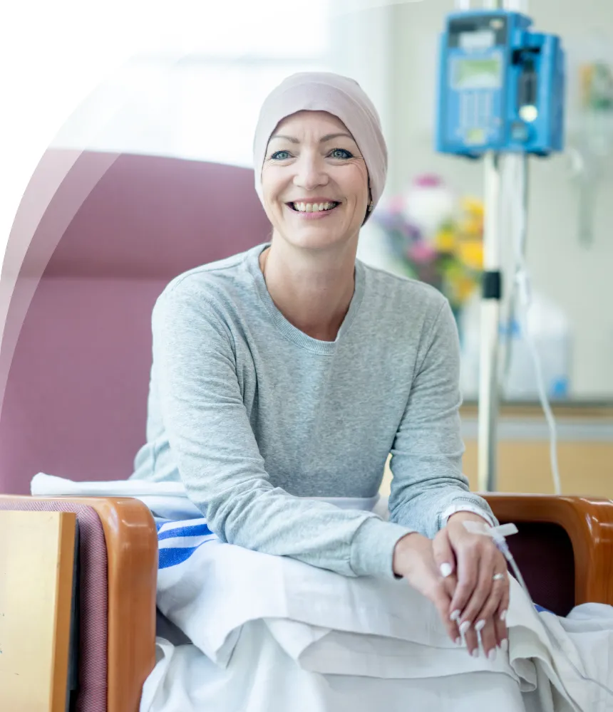 Smiling cancer patient wearing headscarf during chemotherapy treatment in hospital