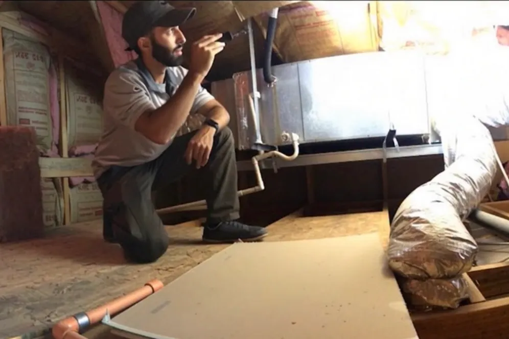 11-month builder warranty inspection in Queen Creek Arizona showing home inspector evaluating HVAC system in attic before warranty expiration