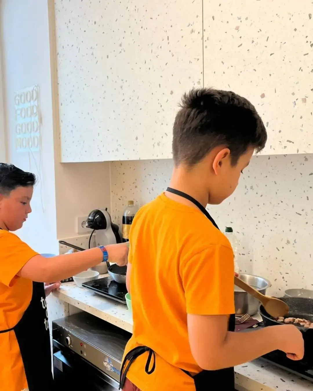 Two women talking in a kitchen while cooking