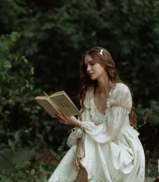 Hand-tied bouquet of pastel wildflowers, including daisies, peonies, and lavender, resting on a rustic wooden table.