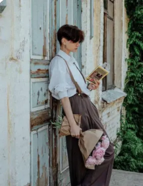 Vintage-inspired table setting with pastel plates, gold cutlery, and lace napkins on a floral tablecloth.
