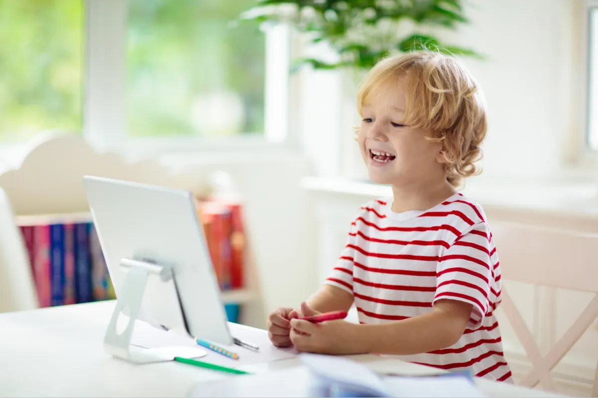 Child waves at laptop