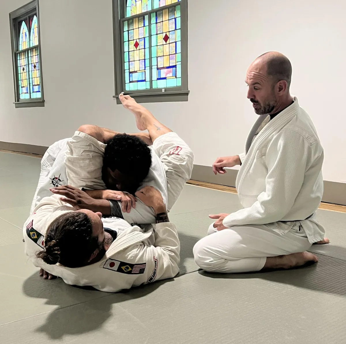 a man in white shirt and black pants on a black mat