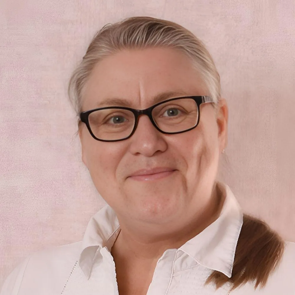 Johanna med solglasögon framför ett rappsfält.