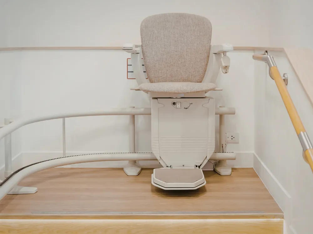 A motorized stair lift installed along a residential staircase, demonstrating how TCP Building Corp creates safe, reliable, and comfortable lift solutions that help individuals with limited mobility move easily between floors without strain or risk.
