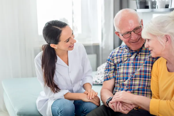 woman talking with older couple on couch