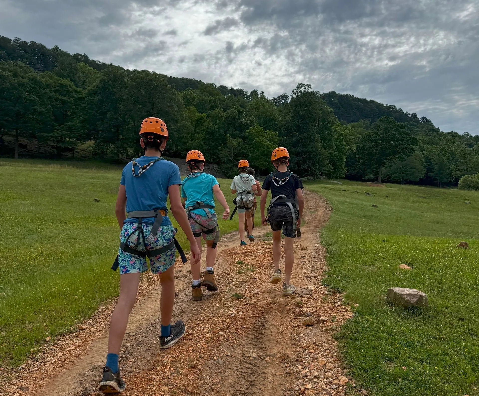 Four young men hike up to a via ferrata climb