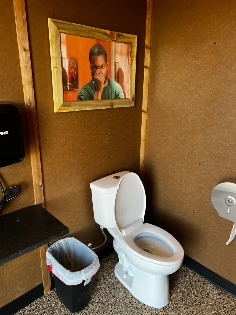 Clean private restroom at SOBO's Campground with modern fixtures, rustic wood accents, and decorative artwork creating a comfortable guest experience.